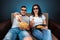 A man and a woman, a family watching a movie or a series in 3D glasses, a blue background. The concept of a cinema, films,