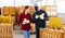 Man and woman farmers talking during stacking pumpkins