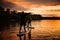 Man and woman float along the river standing on sup boards with oars