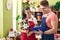 Man and woman florists holding bouquet of flowers and clipboard at flower shop