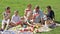 Man and woman with four kids having watermelon