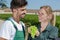 Man and woman gardeners standing among grapes