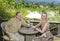 The man and the woman with glasses sit on a balcony overlooking rice terraces and mountains