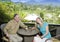 Man and the woman with glasses sit on a balcony overlooking rice terraces and mountains