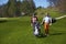 Man and woman golfers walking on a golf course