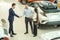 Man and woman greeting a salesman in dealership