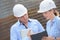 Man and woman in hardhats looking at clipboard