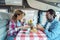 Man and woman have lunch together inside a modern camper van rv vehicle in renting holiday vacation. Happy adult couple enjoy off