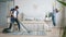 Man and woman having fun during clean-up at home vacuuming and dusting dancing