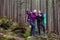 Man and Woman Hikers Staying in Dense Old Forest Smiling and Pointing