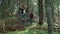 Man and woman hiking in fairytale forest. Smiling hikers walking in green woods