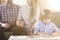 Man and woman holding hands on a couch and a boy in front drawing pictures by a table during a family psychotherapy session.