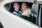 A man and a woman are hugging in the back seat of the car. Portrait of lovers looking at the open window of the car and