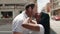 Man and woman interracial couple standing together and kissing at street