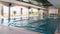 Man and a woman jump into the pool and swim a race. Scene. Young couple of swimmers inside swimming pool