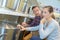 Man and woman kneeling beside shelf saucepans