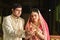 Man & Woman With Lit Earthen Lamp During Festival