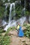 Man and woman in a long dress cuddle against the backdrop of a cascade of waterfall Soroa, Pinar del Rio, Cuba