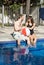 Man and Woman Lounging Beside a Pool - Vertical