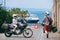 Man and woman. Love and relationships. Tourism and travel. Motorcycle for tours around the world. Street of sunny Italy. Ocean