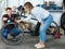 Man with woman are lubricating the bicycle mechanism with silicone in the workshop.