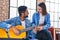 Man and woman musicians having classical guitar lesson at music studio