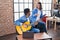 Man and woman musicians playing classical guitar using smartphone at music studio