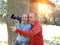 Man and woman near an oak in summer day show to the side and photograph on the big camera