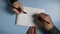 A man and a woman in a notebook perform a parkinson`s disease test and hand tremor diagnosis.