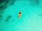 Man and Woman in an orange canoe in tropical waters. Top view from a drone