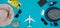 Man and woman pair vacation accessories on the turquoise background. Plane in center. Place for text or logo.