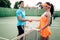 Man and woman partners on outdoor tennis court