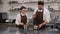 A man and a woman pastry chefs prepare a dessert together in a pastry kitchen.