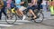 Man and woman pedal with tandem in urban road