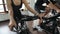 Man and woman pedaling bicycle with his hands on steering wheel.