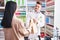 Man and woman pharmacist and client holding shopping bag at pharmacy