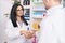 Man and woman pharmacists smiling confident shake hands at pharmacy