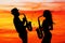 Man and woman play the sax at sunset