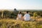 Man and Woman Practicing Yoga and Meditation Outdoors at Sunset with Scenic Landscape and Nature Miracle Giant Stone on