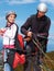 Man, woman and prepare with safety for paragliding, extreme sport and helping by ocean on mountain. Mentor, fitness and