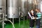 Man and woman in protective mask with beaker in winery shop