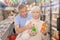 Man and woman purchasers choosing cool drink in supermarket