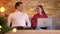 Man and woman put their laptop and smartphone away sit closer and start happily communicating in cosy home atmosphere.