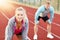 Man and woman racing on outdoor track