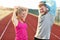 Man and woman racing on outdoor track