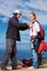 Man, woman and ready with safety for paragliding, extreme sport and helping by ocean in sunshine. Coaching, fitness and