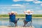 man and woman relax on a pier near a lake sitting