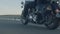 Man and woman riding along road in desert on motorbike, closeup view from below. Couple is riding along the road on