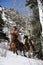 Man and Woman Riding Horses in the Snow