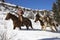 Man and Woman Riding Horses in the Snow